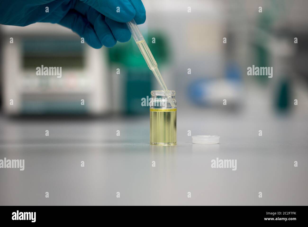 Chemist in a science laboratory using a pipette to analyse Cannabidiol. Legalisation of CBD oil Stock Photo