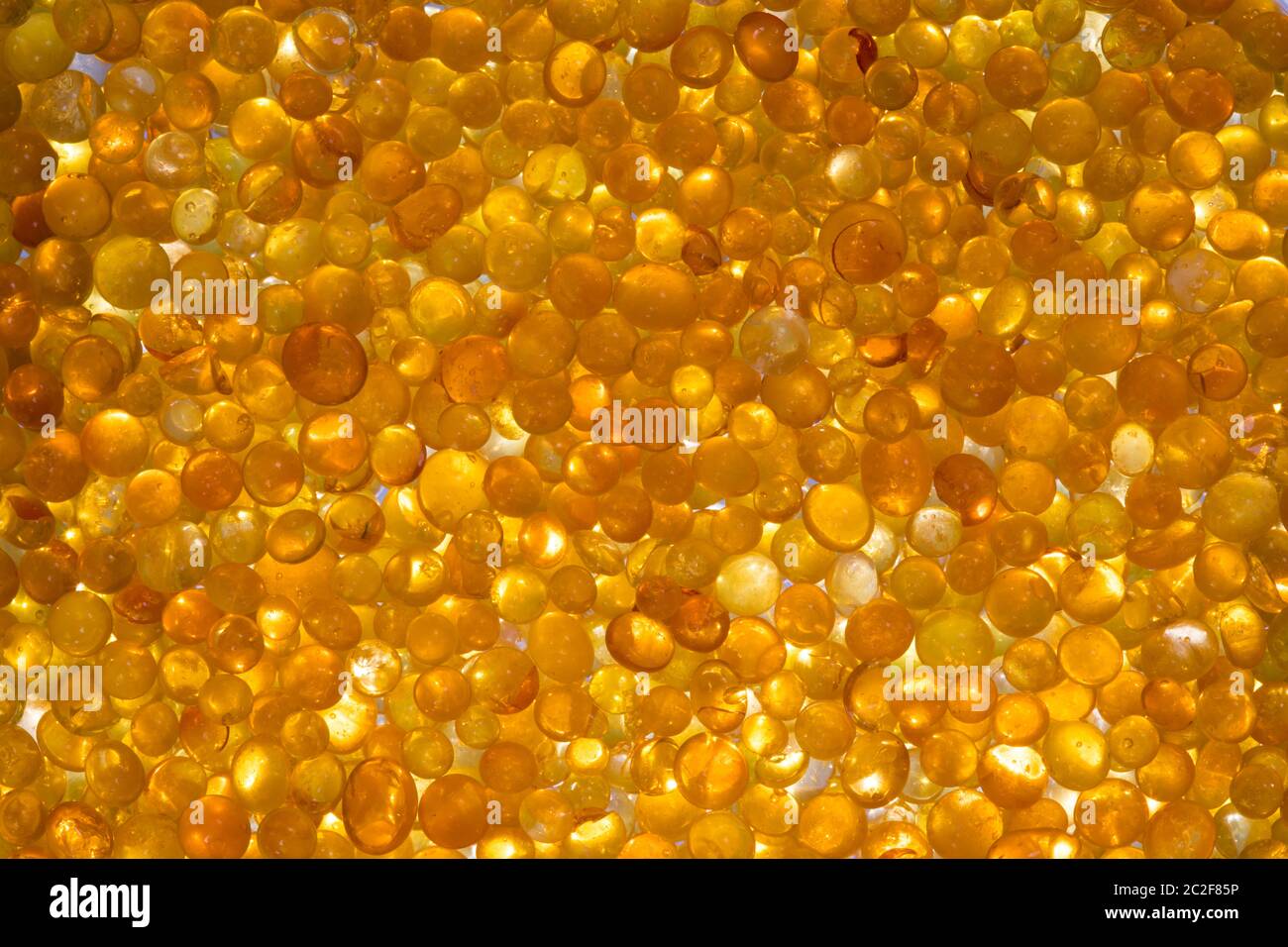 Close up of orange silica gel dessicant. Golden translucent beads with