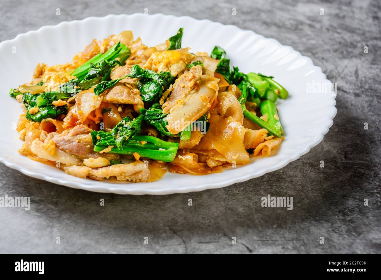 Stir-fried Fresh Rice-flour Noodles With Sliced Pork, Egg and Kale. Quick noodle stir-fry. Stock Photo