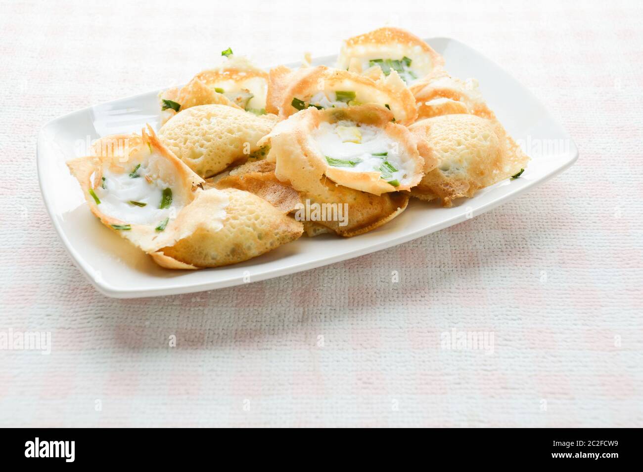 Khanom khrok or coconut-rice pancakes are one of the ancient Thai desserts. They are prepared by mixing rice flour, sugar, and c Stock Photo