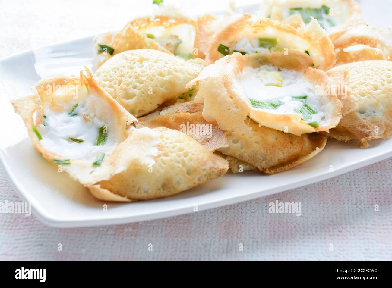 Khanom khrok or coconut-rice pancakes are one of the ancient Thai desserts. They are prepared by mixing rice flour, sugar, and c Stock Photo