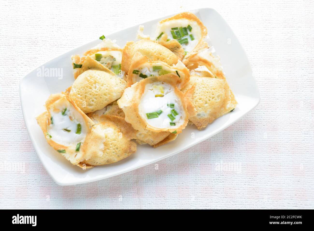 Khanom khrok or coconut-rice pancakes are one of the ancient Thai desserts. They are prepared by mixing rice flour, sugar, and c Stock Photo