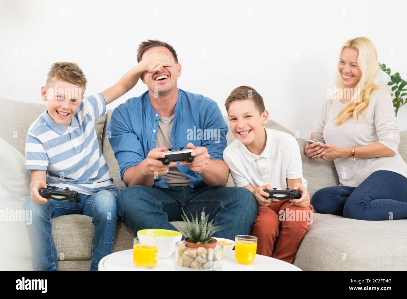 Happy young family playing videogame console on TV. Spending quality  leisure time with children and family concept. Gaming consoles are generic  and de Stock Photo - Alamy