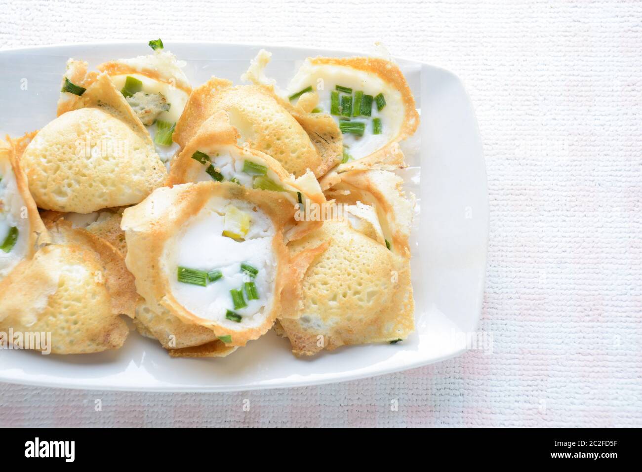 Khanom khrok or coconut-rice pancakes are one of the ancient Thai desserts. They are prepared by mixing rice flour, sugar, and c Stock Photo