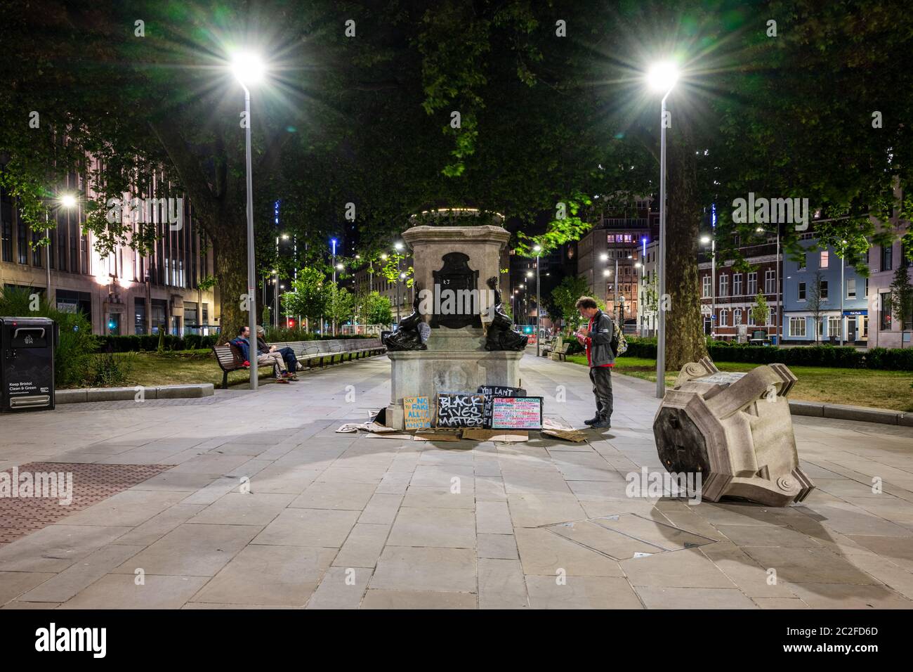 Bristol, England, UK - June 8, 2020: People passing the plinth of the toppled statue of slave trader Edward Colston in Bristol read and leave placards Stock Photo