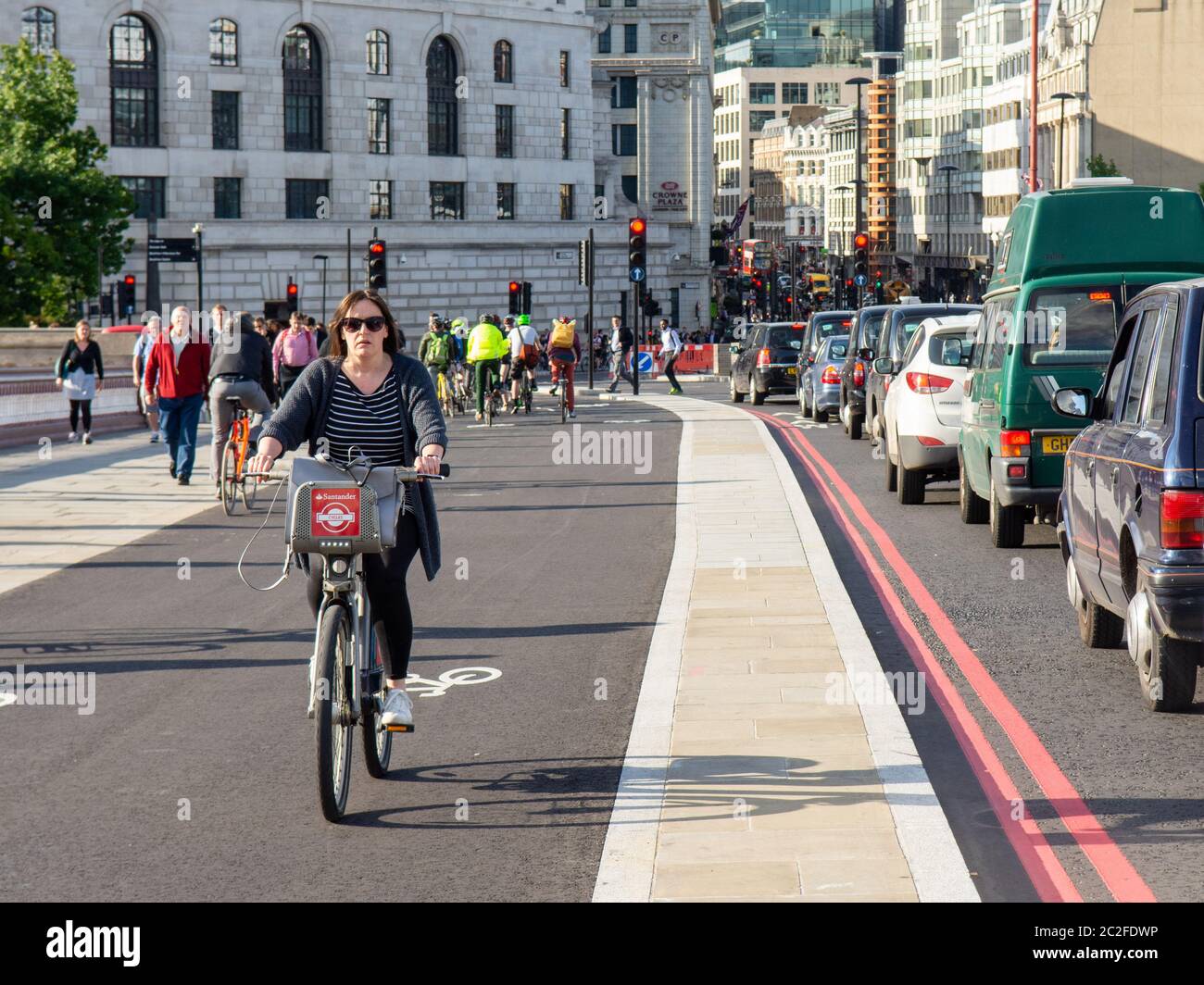 London, England, UK - May 24, 2016: A woman cycles a 'Boris Bike' hire bike on Cycle Superhighway 6 on London's Blackfriars Bridge. Stock Photo