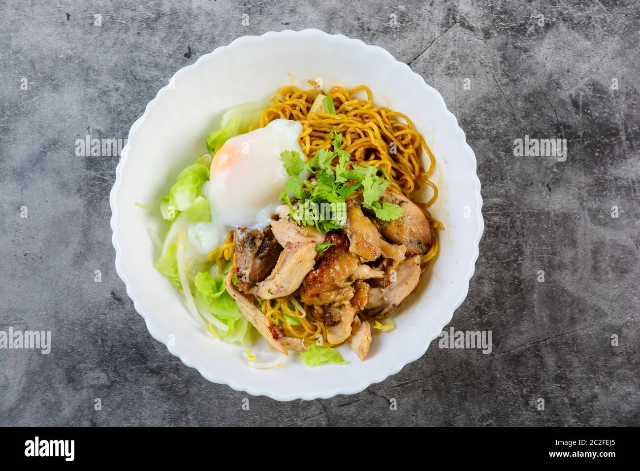 Egg noodles served dry with roasted honey chicken and soft-boiled eggs (onsen tamago eggs) Stock Photo