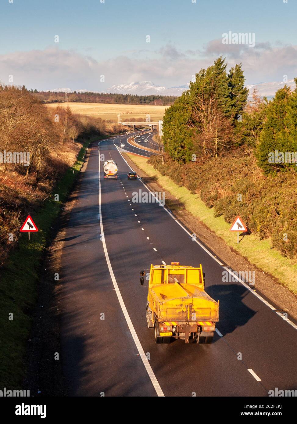 Stirling, Scotland, UK - January 22, 2012: Lorries join the M9 motorway from the M80 at junction 9 near Stirling, with Highland mountains in the dista Stock Photo