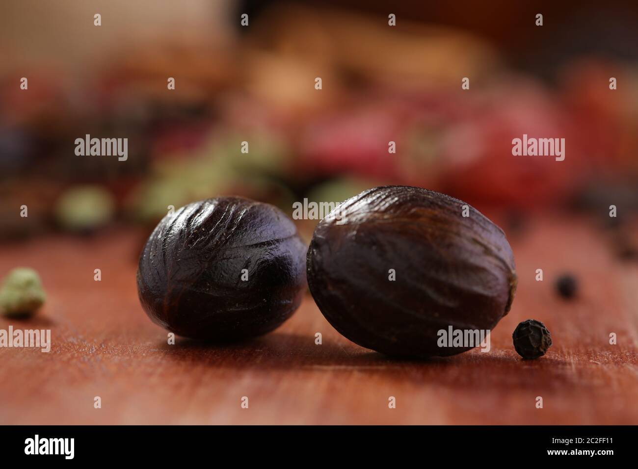 Nutmeg or Jaiphal is an aromatic spice placed over a wooden background, selective focus Stock Photo