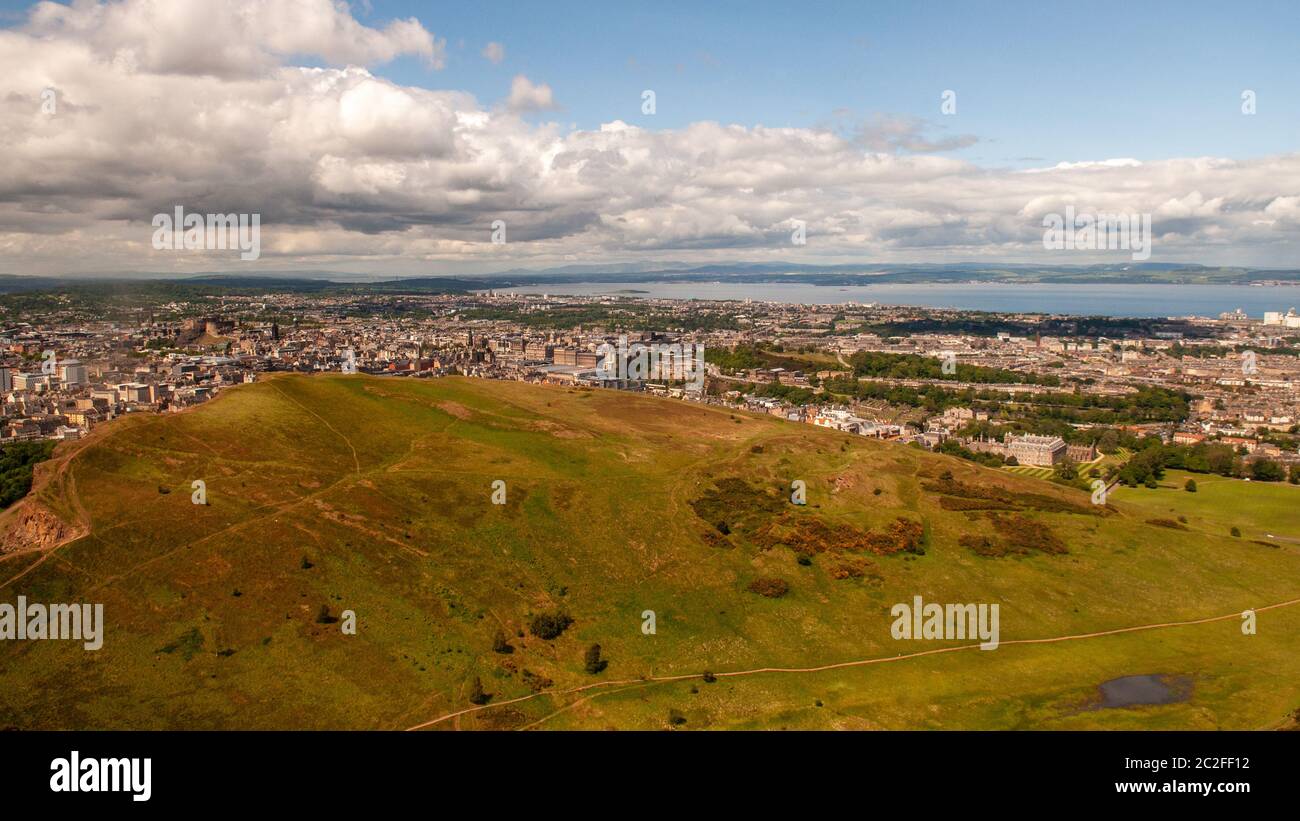 Salisbury Crags, Holyrood Park and the cityscape of Edinburgh are laid out below Arthur's Seat. Stock Photo