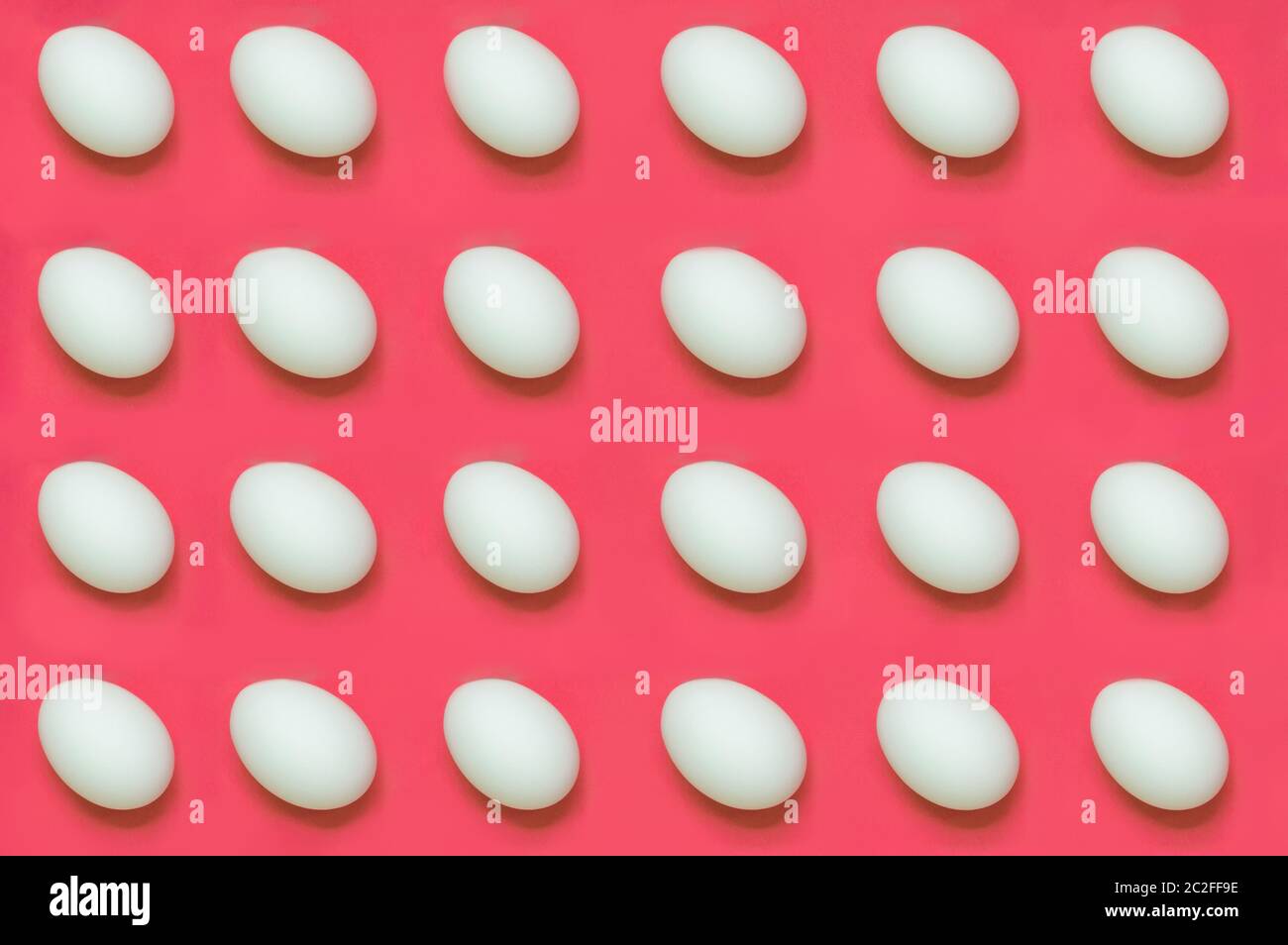 White eggs arranged on solid color background Stock Photo