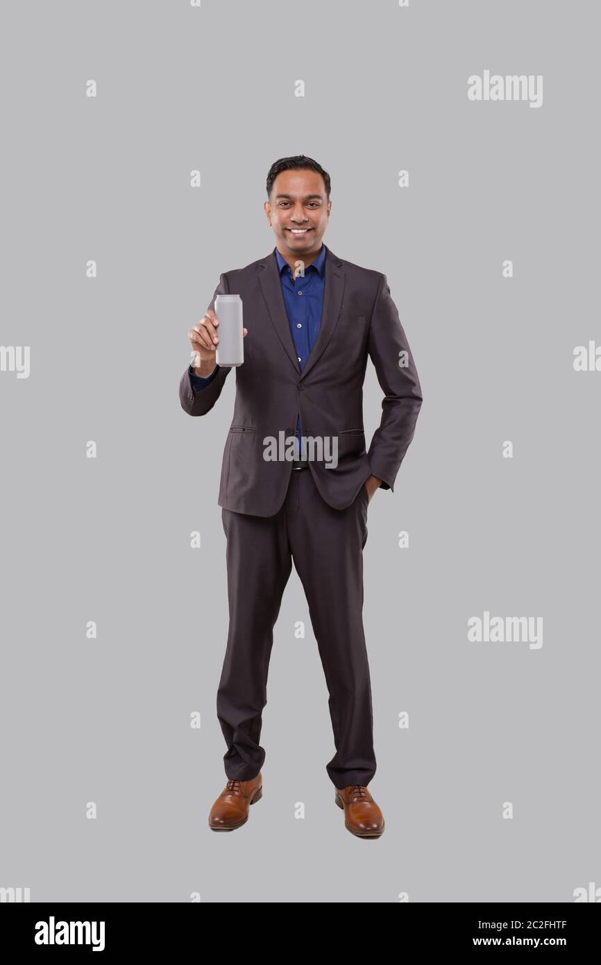Businessman Holding Beer Tin Can. Indian Business man Standing Full Length. Stock Photo