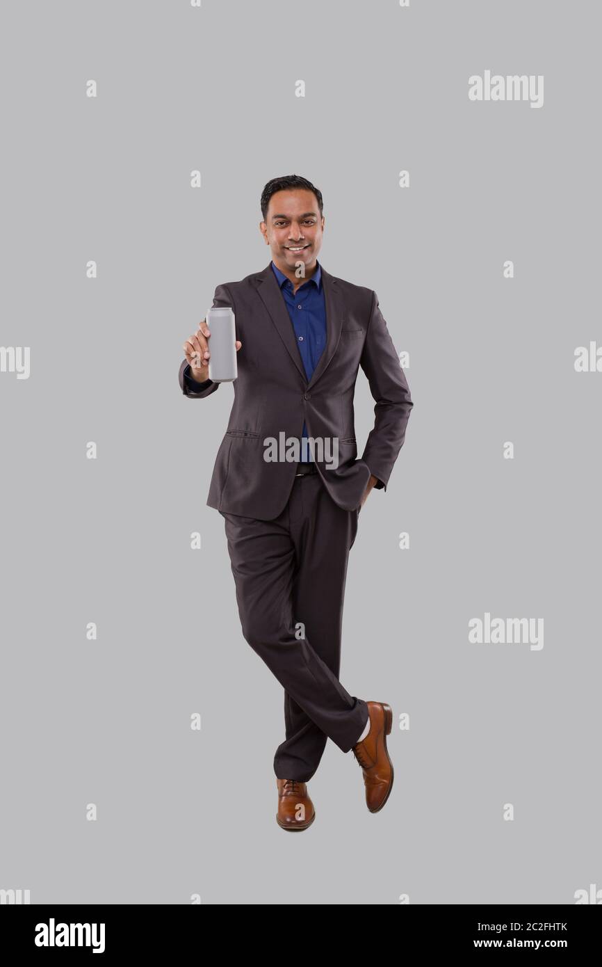Businessman Holding Beer Tin Can. Indian Business man Standing Full Length. Stock Photo