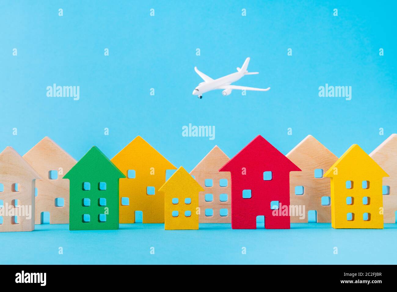 Art design picture of nice wooden figures settlement city residence economy development plane flying isolated over bright vivid shine vibrant blue Stock Photo