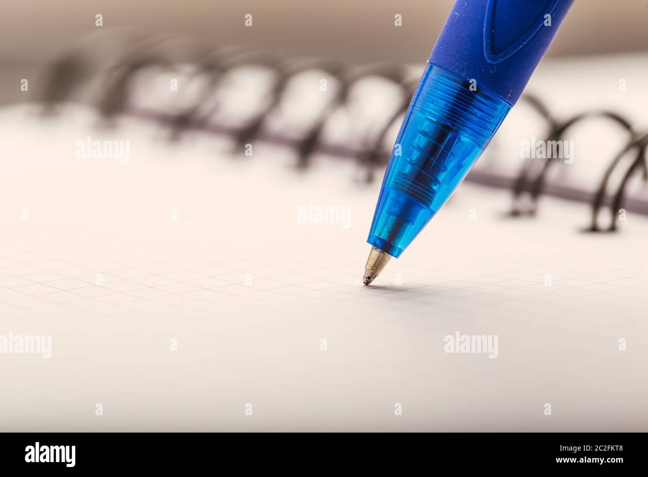 Opened notepad in a cage with an automatic plastic ballpoint pen close-up. Stock Photo