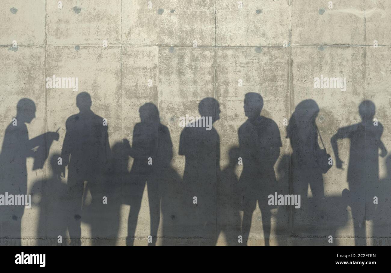 Group of people walking in a relaxed pose cast a shadow on the concrete wall. Conceptual creative illustration with silhouettes of men and women. Copy Stock Photo