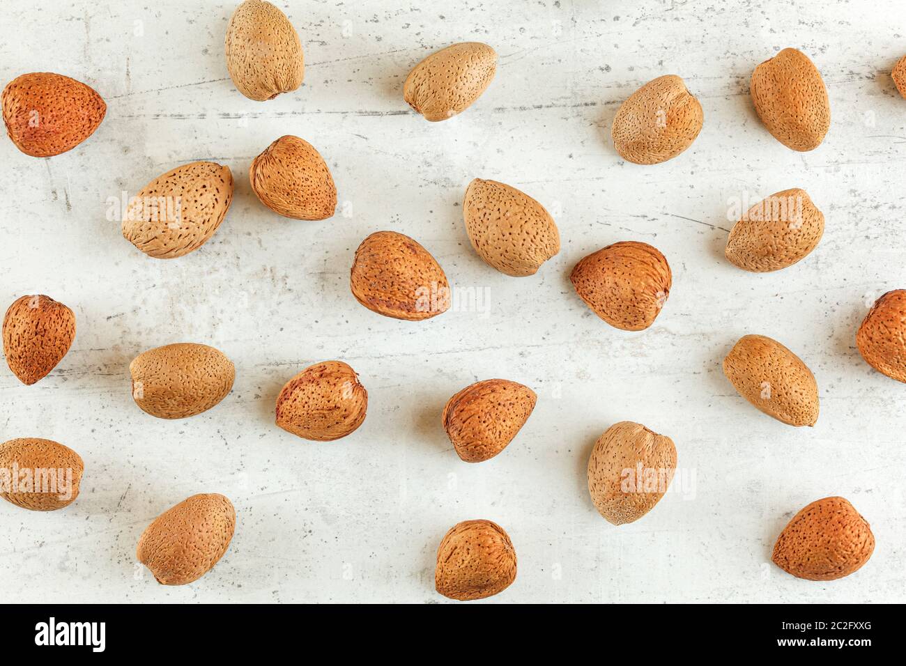 Top down view, whole almonds in shell on white stone board Stock Photo