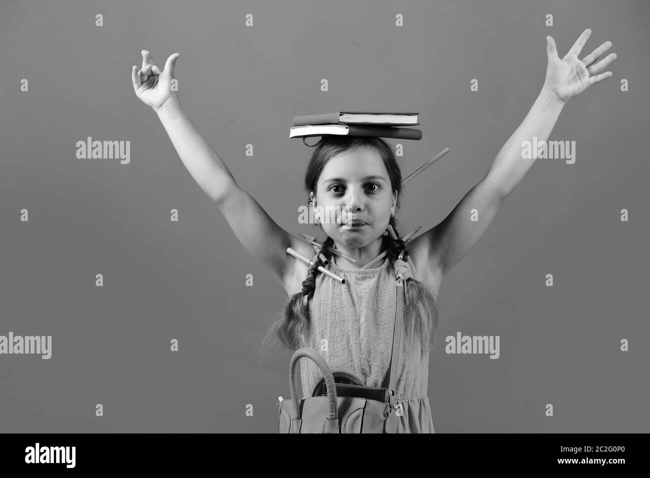 Back To School Concept School Girl With Funny Face Holds Hands Up Isolated On Red Background 