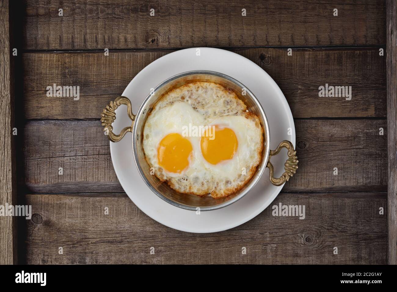 Top view of fried egg in copper pan isolated on rustic wooden table Stock Photo Alamy