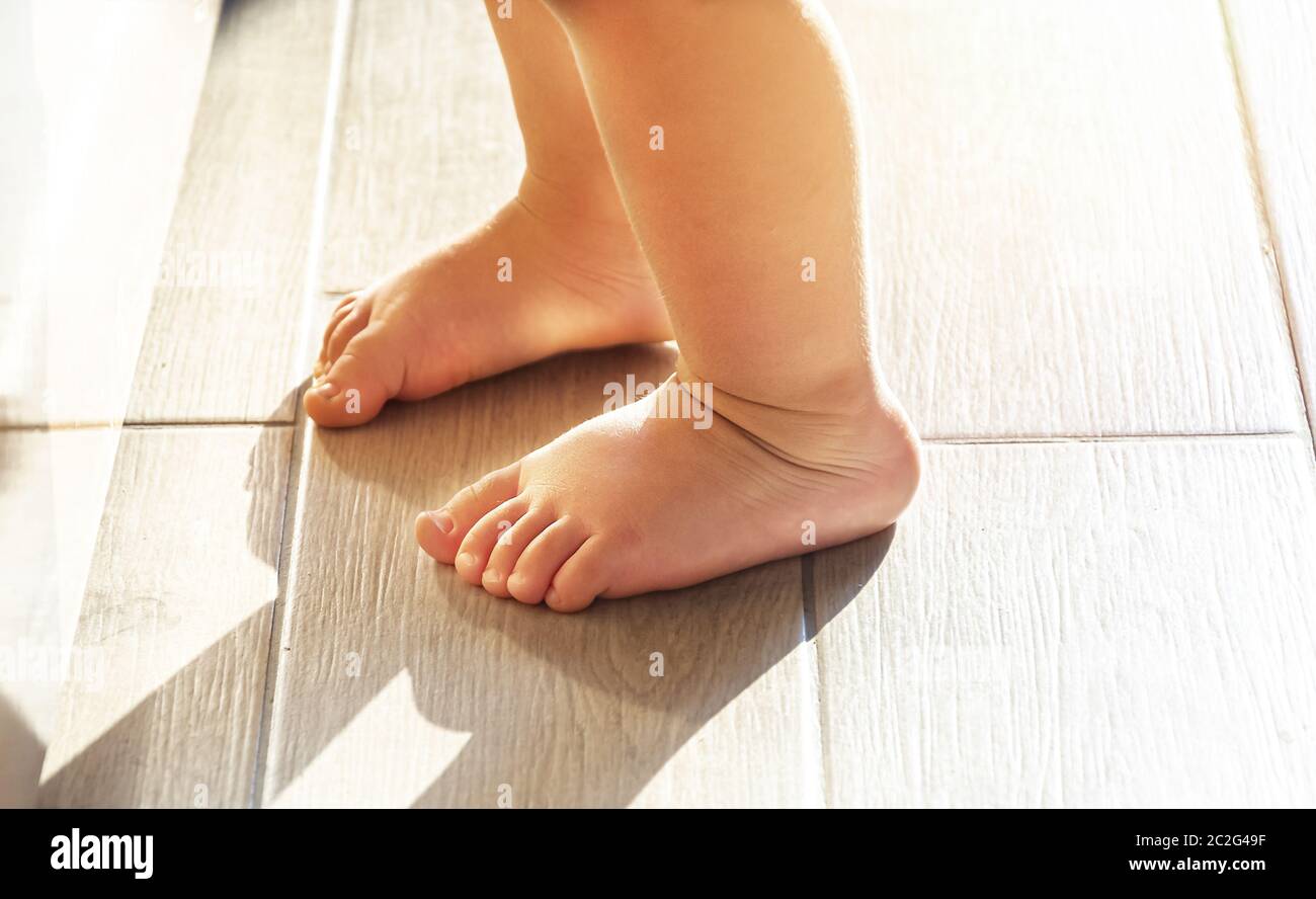 feet of a toddler learning to walk. Stock Photo