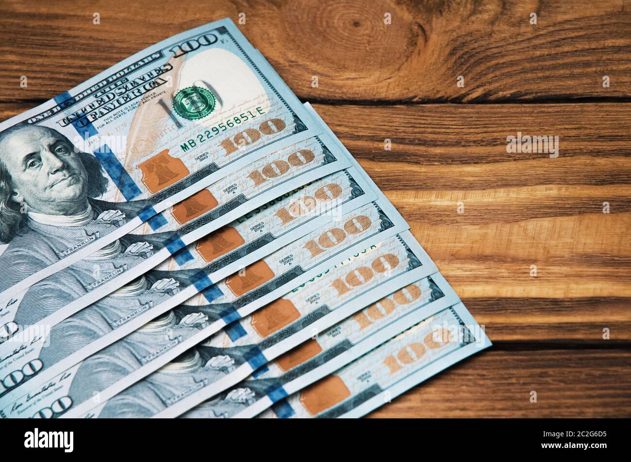 A row of cash hundred American banknotes on a wooden background Stock ...