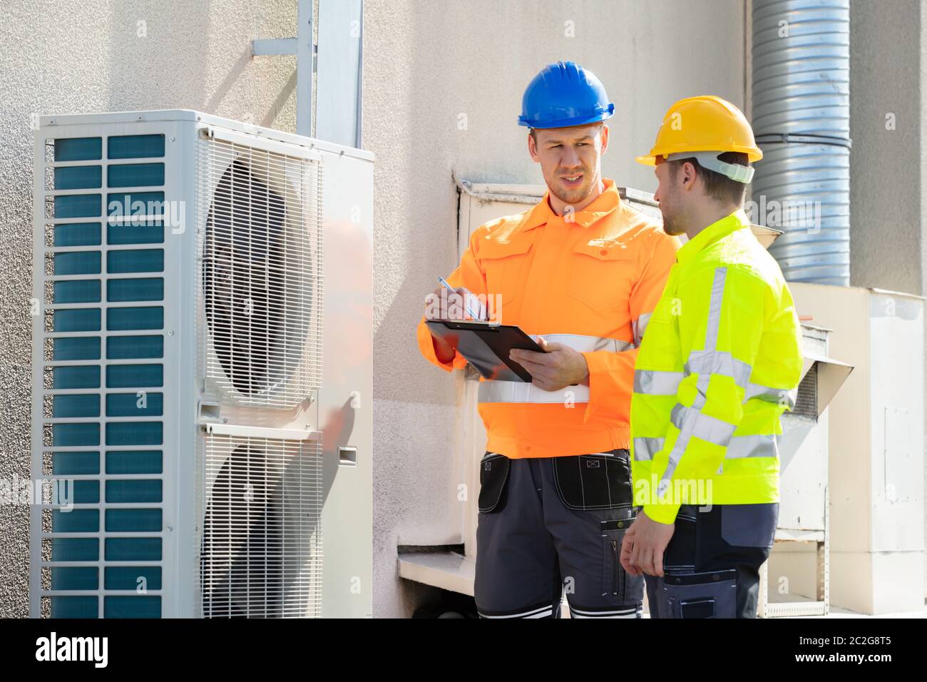 Two Electricians Men Wearing Safety Jackets Checking Air Conditioning ...