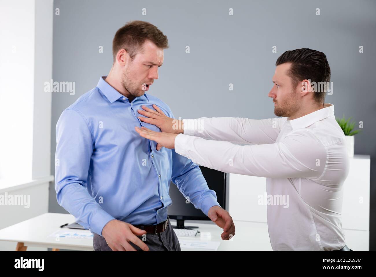 Two Angry Young Businessmen Quarreling With Each Other Fighting In The Office Stock Photo