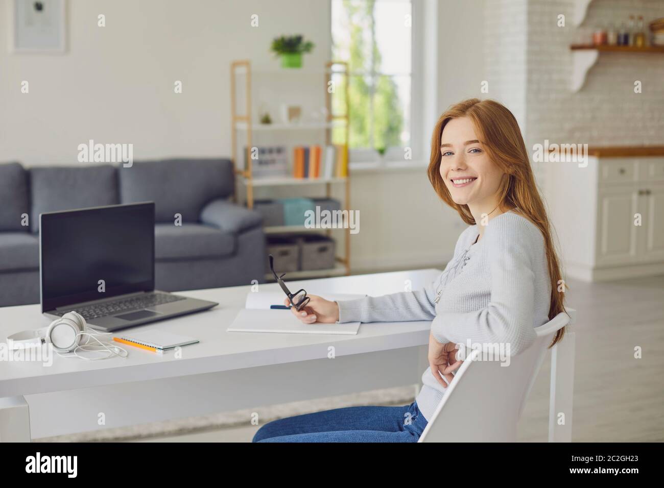 Cheerful female freelancer working from home office Stock Photo