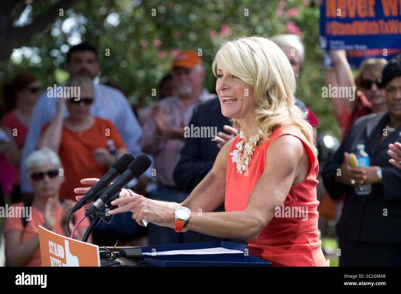 Austin Texas USA, July 2013: State Sen. Wendy Davis, D-Ft. Worth, speaks at a pro-choice rally as activists continue to descend on the Capitol while Texas lawmakers struggle to pass a bill limiting the number of abortion providers by increasing medical standards for clinics to the level of ambulatory surgical centers. Cecille Richards, president of Planned Parenthood, stands behind Davis wearing a red dress. ©Bob Daemmrich Stock Photo