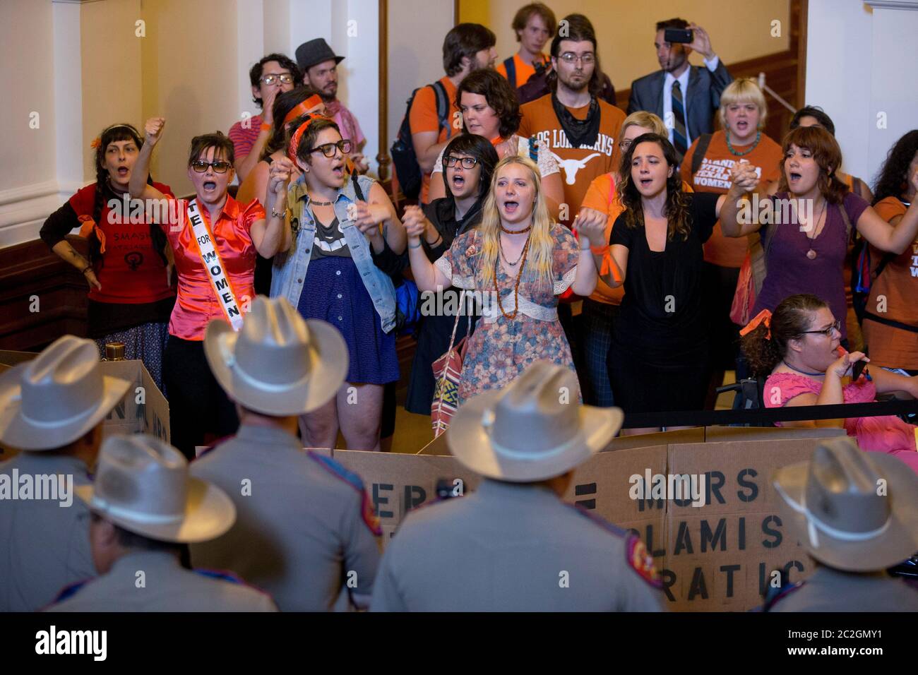 Austin Texas USA, July 2013: A rowdy group of women's rights and pro-choice advocates demonstrates outside the Texas House of Representatives chamber as Dept. of Public Safety troopers guard the doors. The women are protesting against a final House vote that restricts abortion providers in Texas. The bill gets a final look in the Senate later this week.   ©Bob Daemmrich Stock Photo
