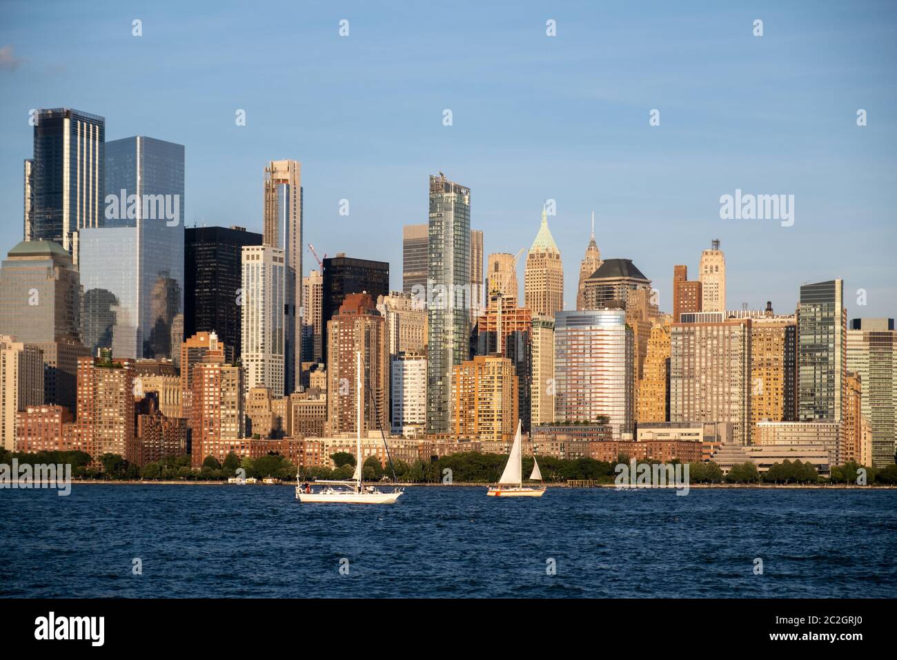 Lower Manhattan skyline with boat and ferry on Hudson river view from Liberty State Park in late summer Stock Photo