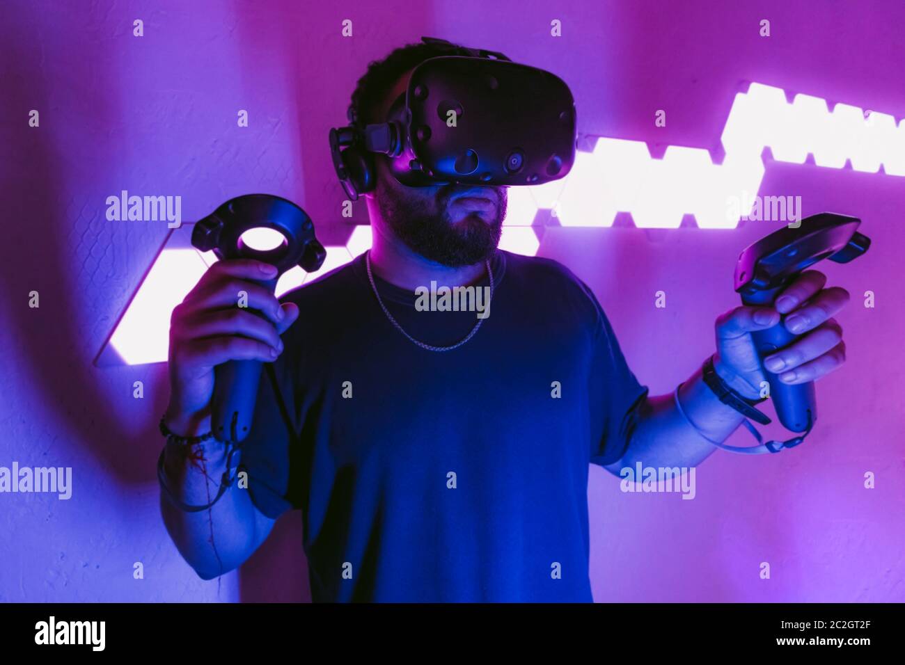 Man in a virtual reality helmet. Neon room with VR games Stock Photo - Alamy