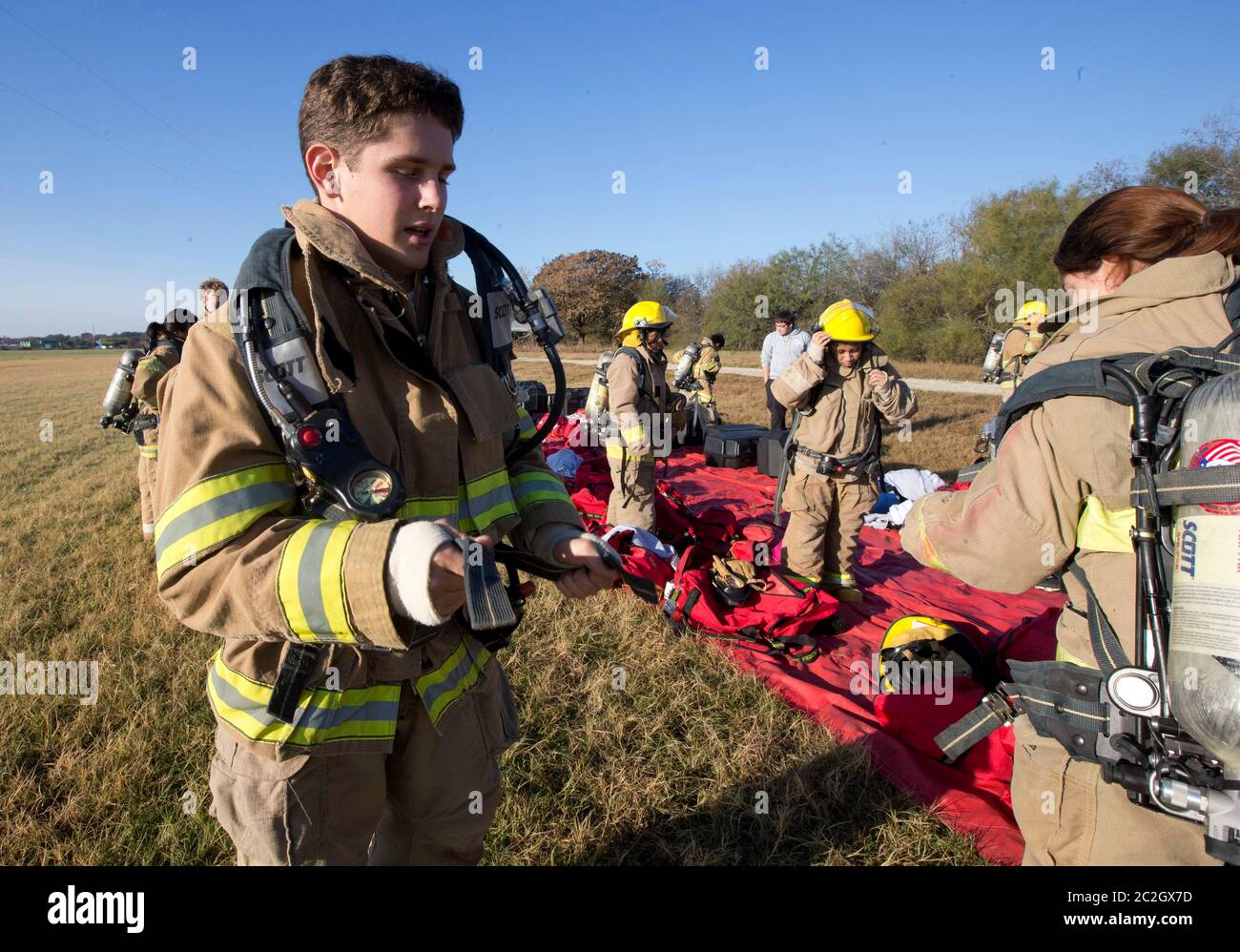 Austin Texas USA, February 4 2014: Students from the LBJ High School Fire Training Academy wearing turnout gear prepare for a training exercise.  Students graduating from the two-year program will be eligible for emergency medical technician EMT certification and possess advanced fire fighting skills. ©Bob Daemmrich Stock Photo
