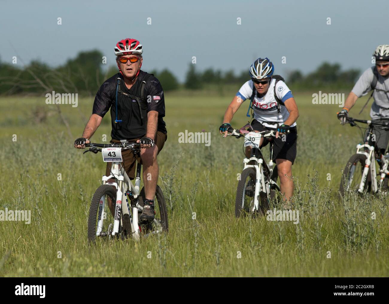 Crawford Texas USA, May 2 2014: Former President George W. Bush leads a pack of bicycle riders through his Prairie Chapel Ranch outside Crawford in the fourth annual Wounded Warrior 100K. The three-day event featured 17 invited U.S. soldiers injured in recent combat in Iraq and Afghanistan.   ©Bob Daemmrich Stock Photo