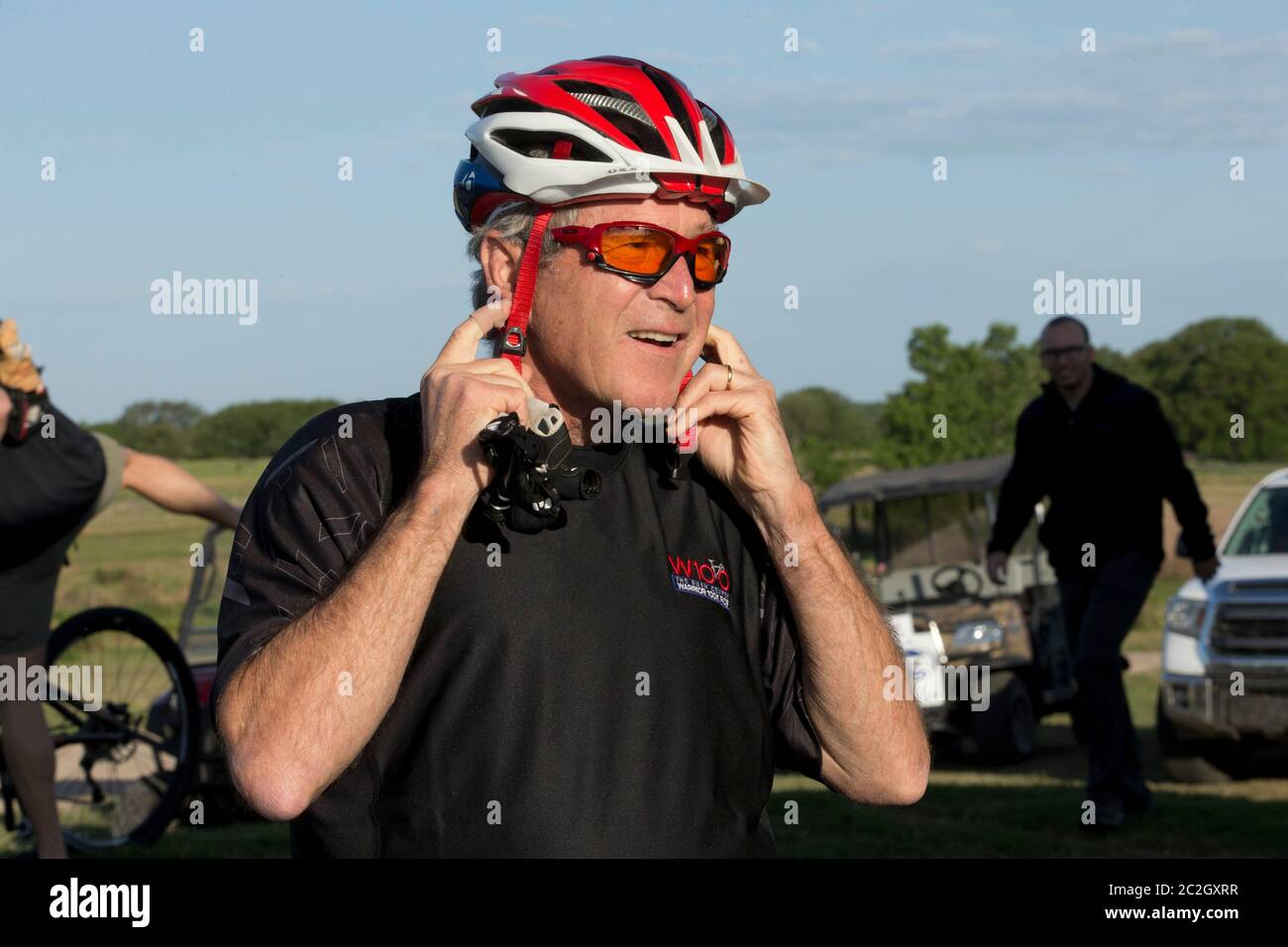 Crawford Texas USA, May 2 2014: Former President George W. Bush readies his headgear before leading a pack of bicycle riders through his Prairie Chapel Ranch outside Crawford, Texas in the fourth annual Wounded Warrior 100K. The three-day event featured 17 U.S. soldiers injured in recent combat in Iraq and Afghanistan.   ©Bob Daemmrich Stock Photo