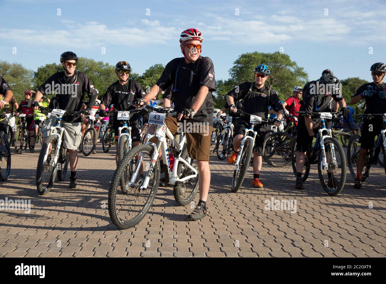 Crawford Texas USA, May 2 2014: Former President George W. Bush pauses before leading a pack of bicycle riders through his Prairie Chapel Ranch outside Crawford in the fourth annual Wounded Warrior 100K. The three-day event featured 17 U.S. soldiers injured in recent combat in Iraq and Afghanistan.   ©Bob Daemmrich Stock Photo