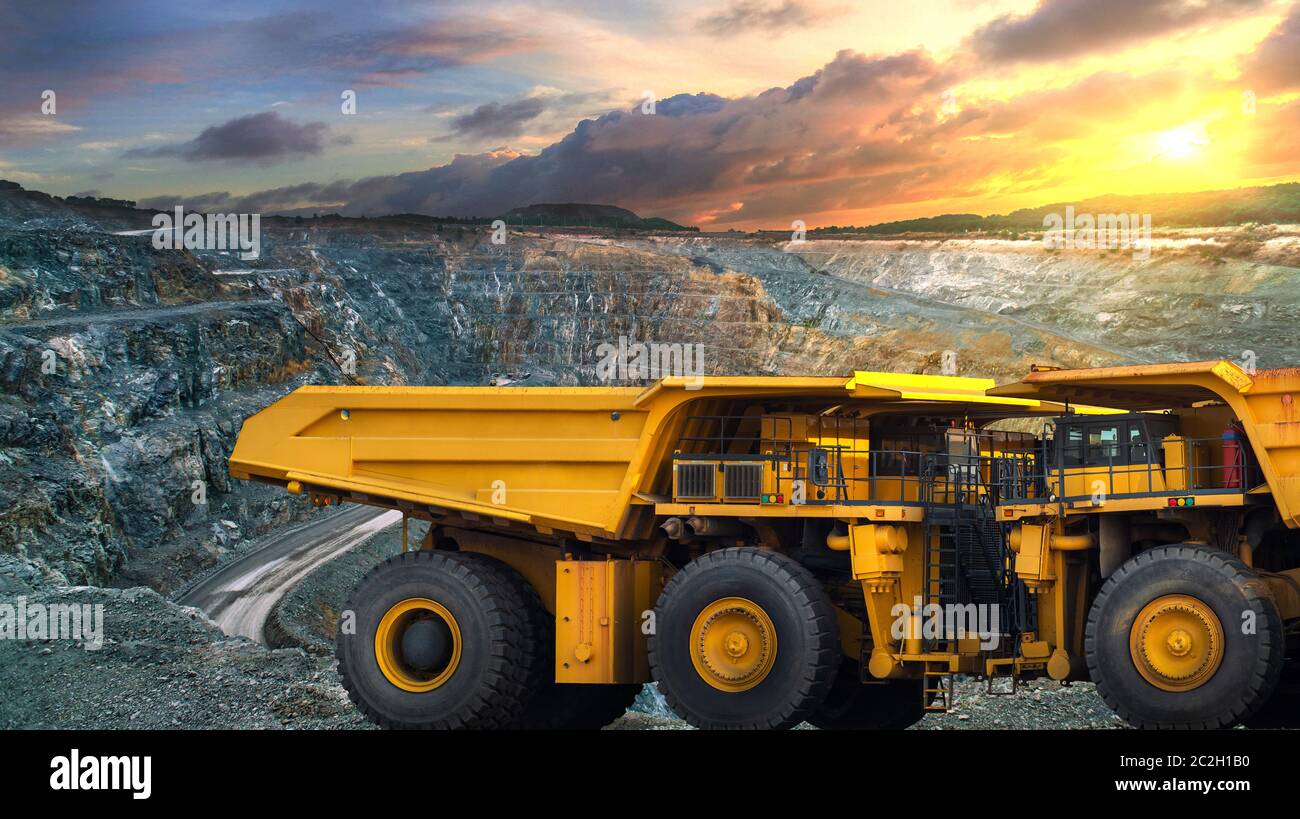 Yellow dump truck loading minerals copper, silver, gold, and other  at mining quarry. Stock Photo