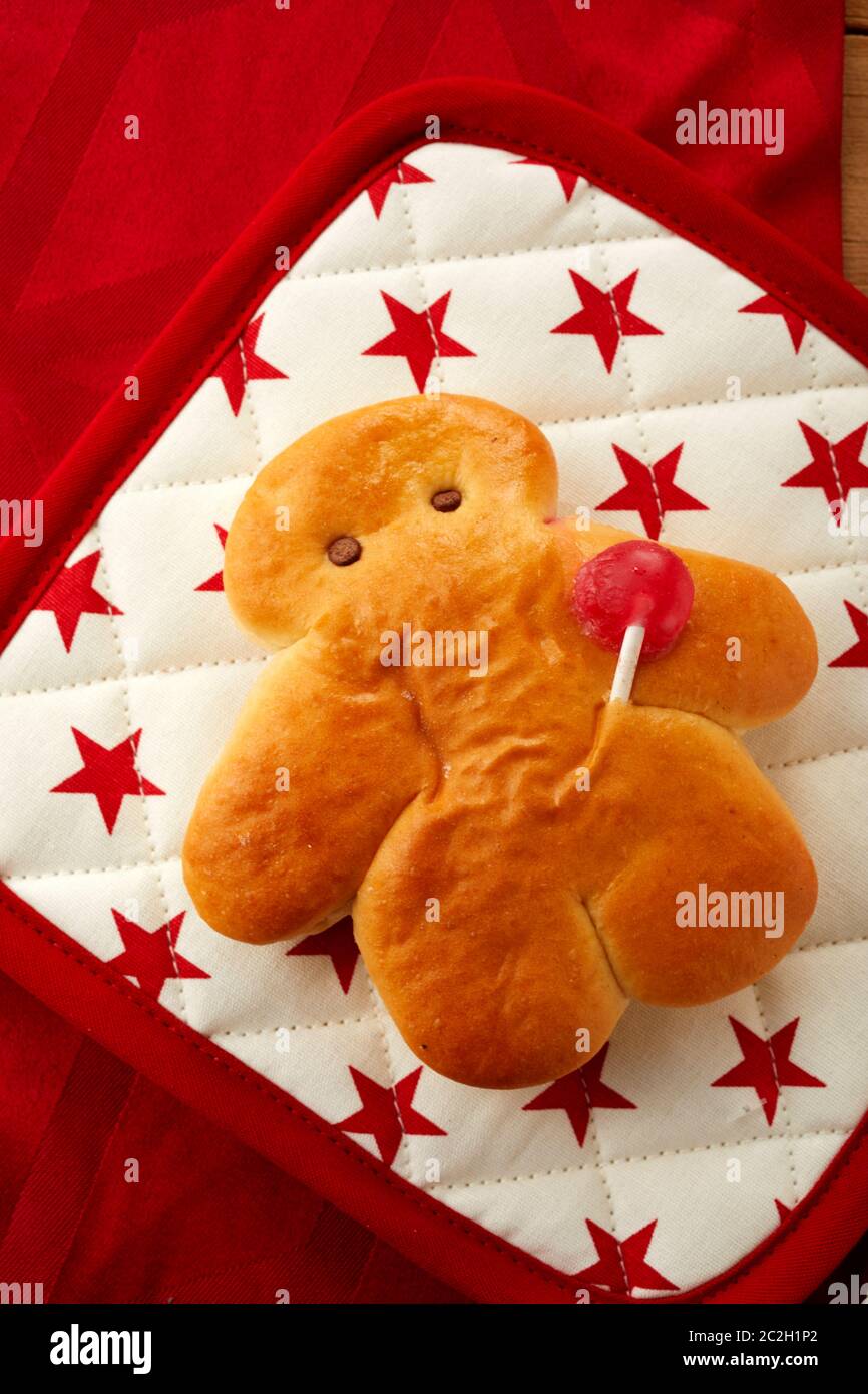 Home baked mini Stutenkerl with festive red stars on a cloth to celebrate a traditional St Nicholas day in Germany viewed close up from above Stock Photo