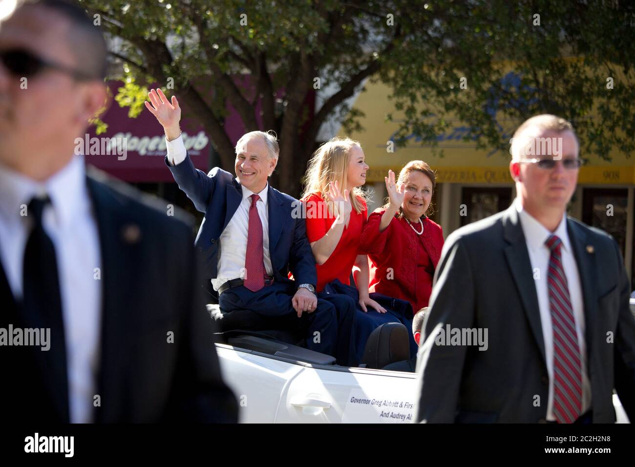 Austin Texas USA, January 20 2015: Texas Gov. Greg Abbott, his daughter, Audrey, and his wife, Cecelia, wave to the crowd as they ride in a convertible car during parade after Abbott's swearing-in ceremony at the Texas Capitol. Abbott becomes the 48th Governor of Texas, succeeding Rick Perry, the longest serving Texas Governor at 14 years.  ©Bob Daemmrich Stock Photo