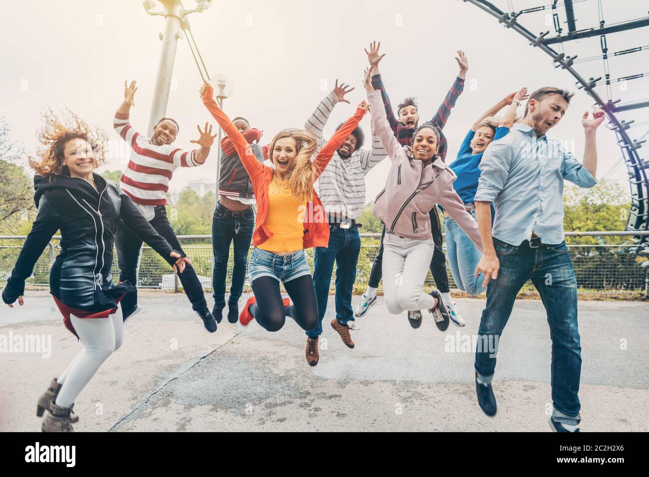 Diversity friends jumping in the park being cheerful and carefree Stock ...