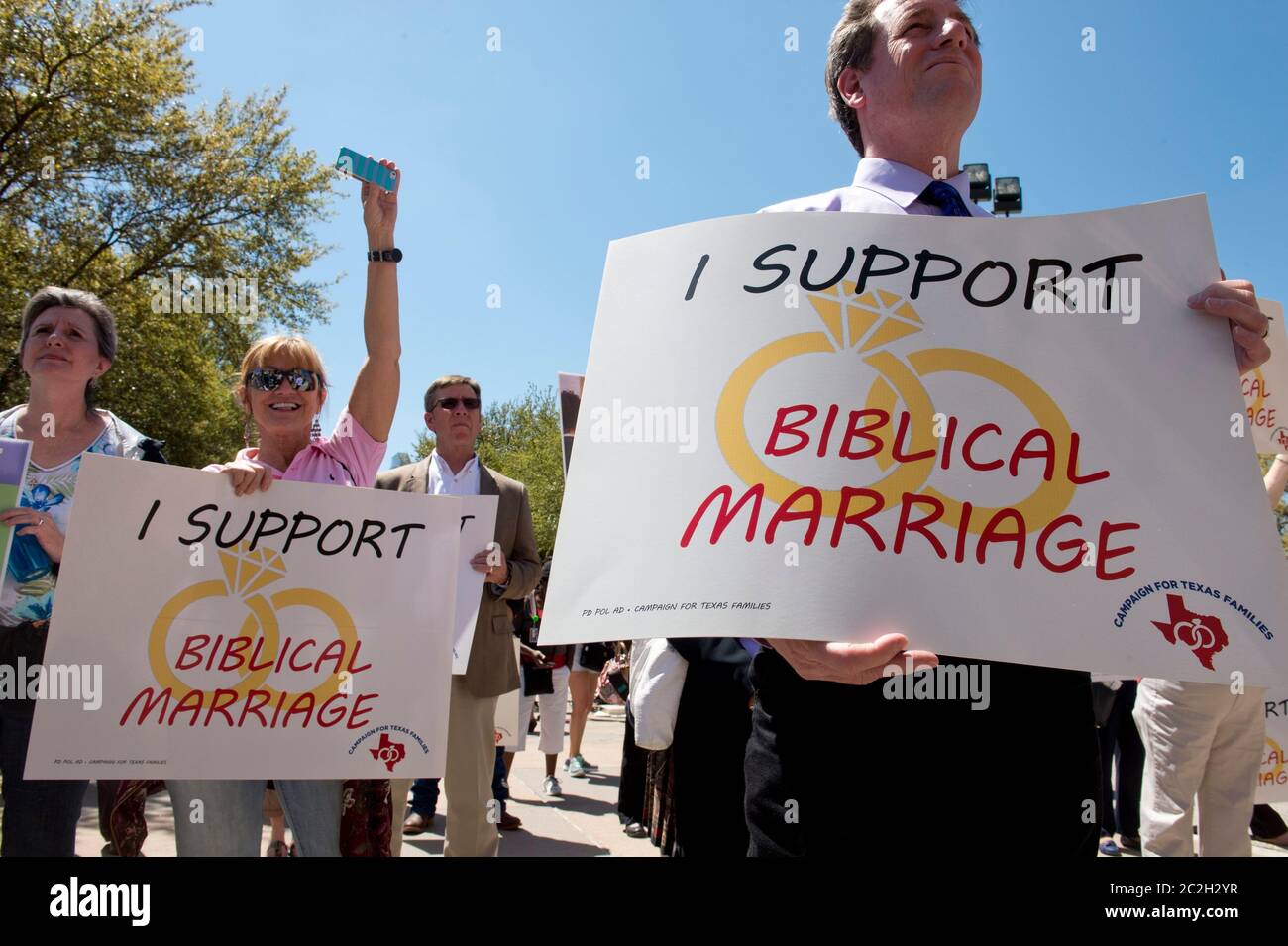 Austin Texas USA, March 24 2015: Anti-gay marriage protesters hold signs as controversial Alabama Supreme Court Chief Justice Roy Moore speaks at a rally at the Texas Capitol.  Moore has told Alabama judges to ignore a recent federal court ruling allowing gay marriage in the state.   © Bob Daemmrich Stock Photo