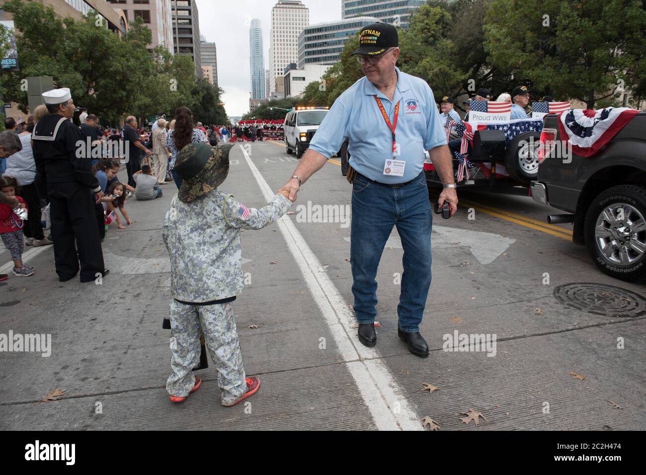 Austin Texas USA, November 11 2015: Vietnam veteran Ken Steffek (r) greets a young boy dressed in camouflage during the annual Veterans Day parade up Congress Avenue.  ©Bob Daemmrich Stock Photo