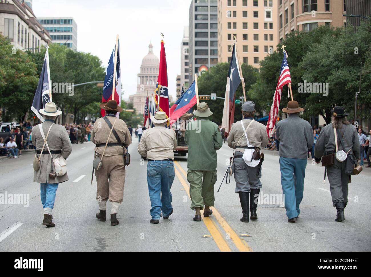 Austin Texas USA, November 11 2015: A group from the Sons of Confederate Veterans display Civil War Confederate battle flags alongside the U.S. flag  during the annual Veterans Day parade up Congress Avenue.   ©Bob Daemmrich Stock Photo