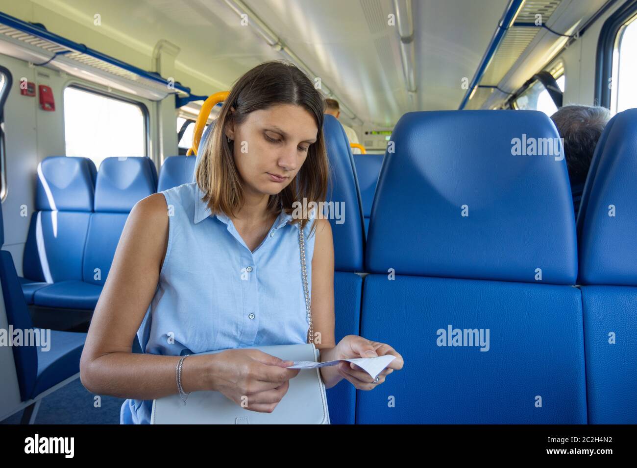 A girl in an electric train looks at a ticket Stock Photo - Alamy