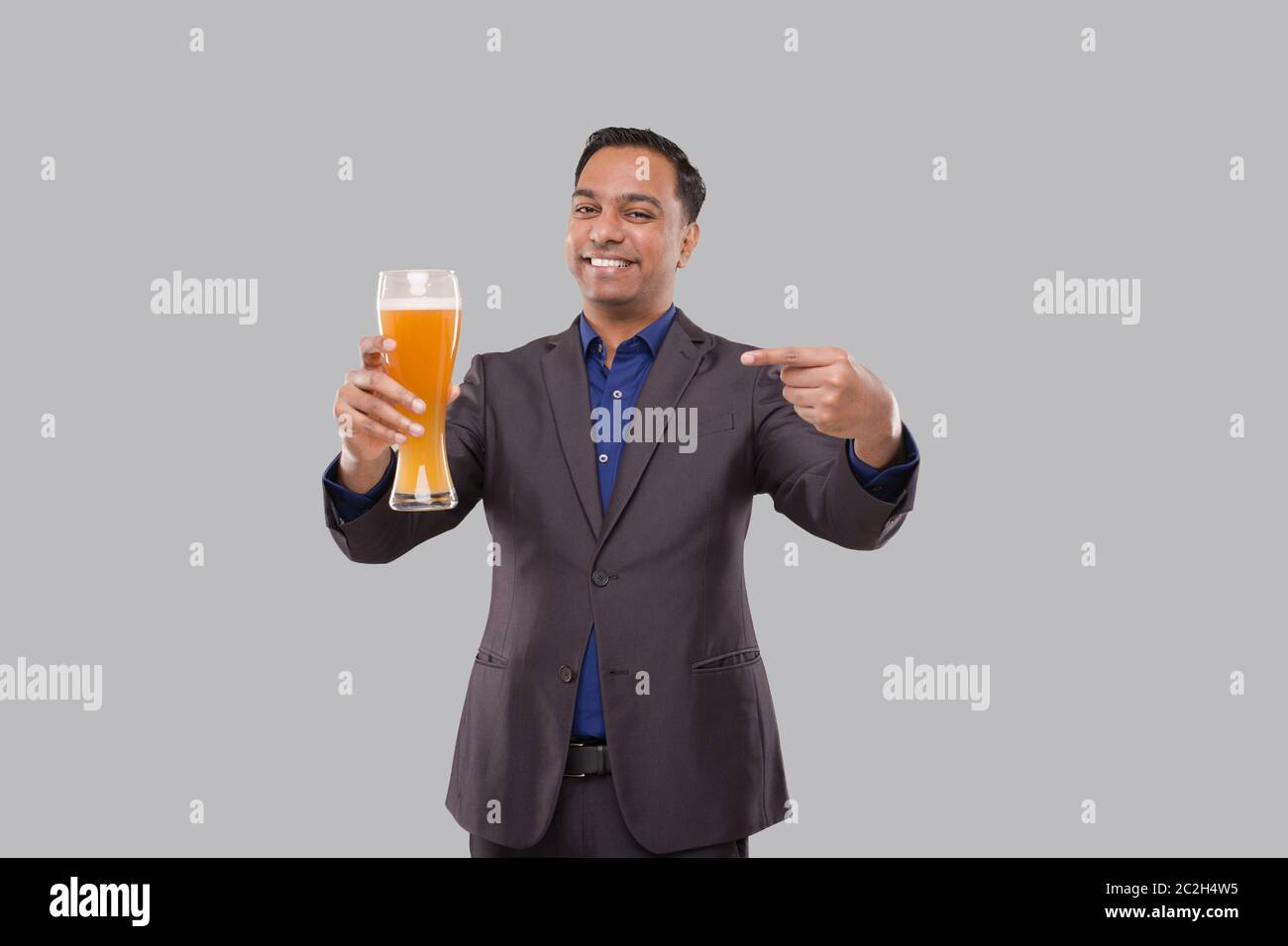 Businessman Pointing at Beer Glass. Indian Business man with Beer in Hand Stock Photo