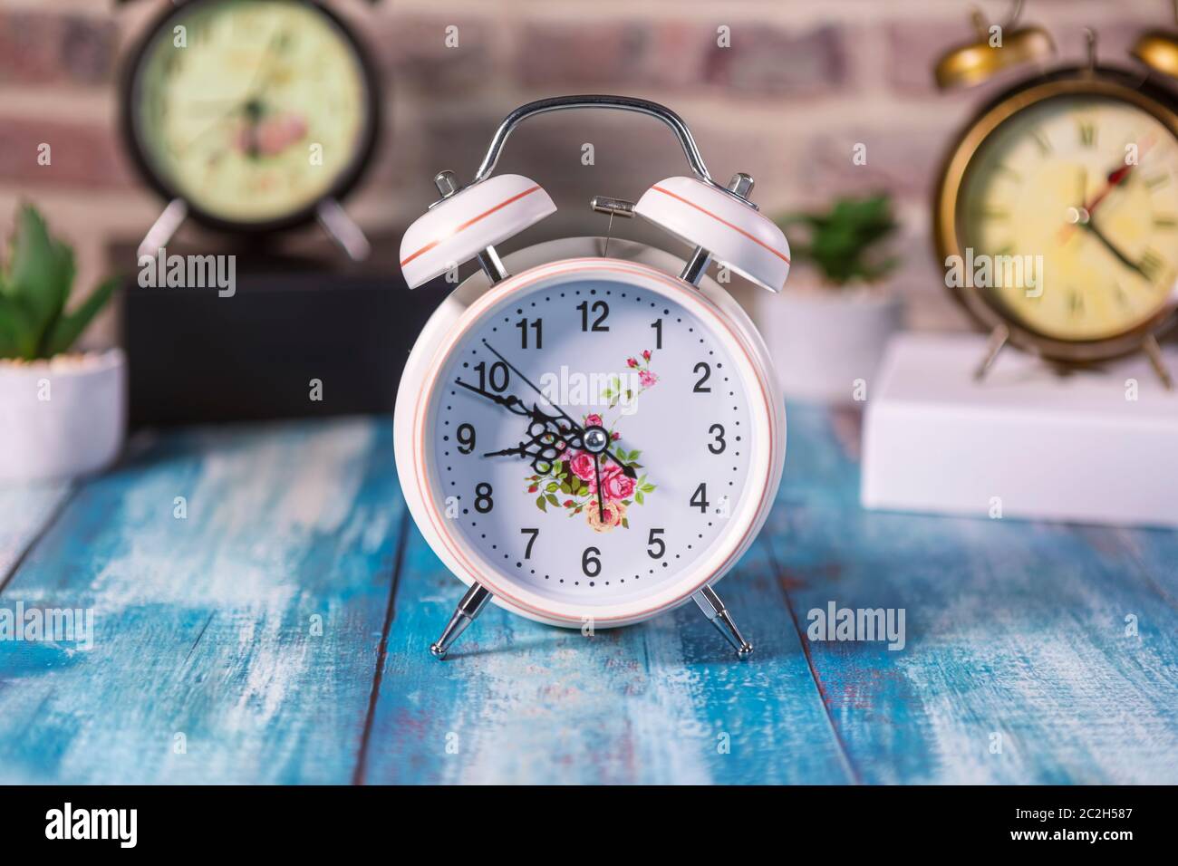 Vintage background with retro alarm clock on table. Focus on first ...