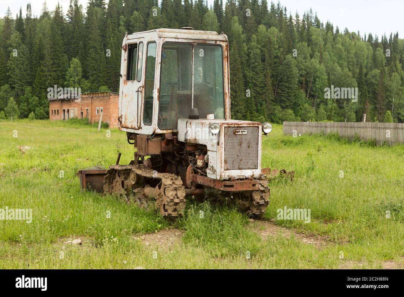 Old tractor on a field in the village in the summer Stock Photo - Alamy