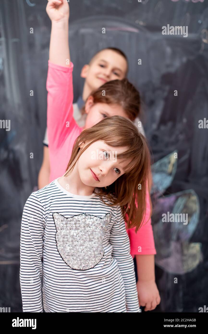 group of kids standing in front of chalkboard Stock Photo