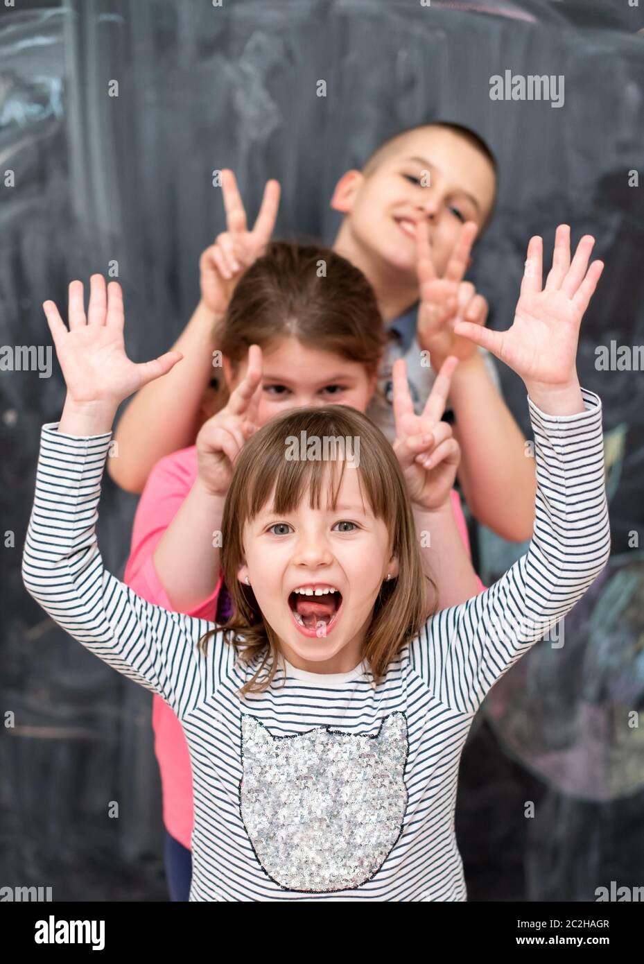 group of kids standing in front of chalkboard Stock Photo