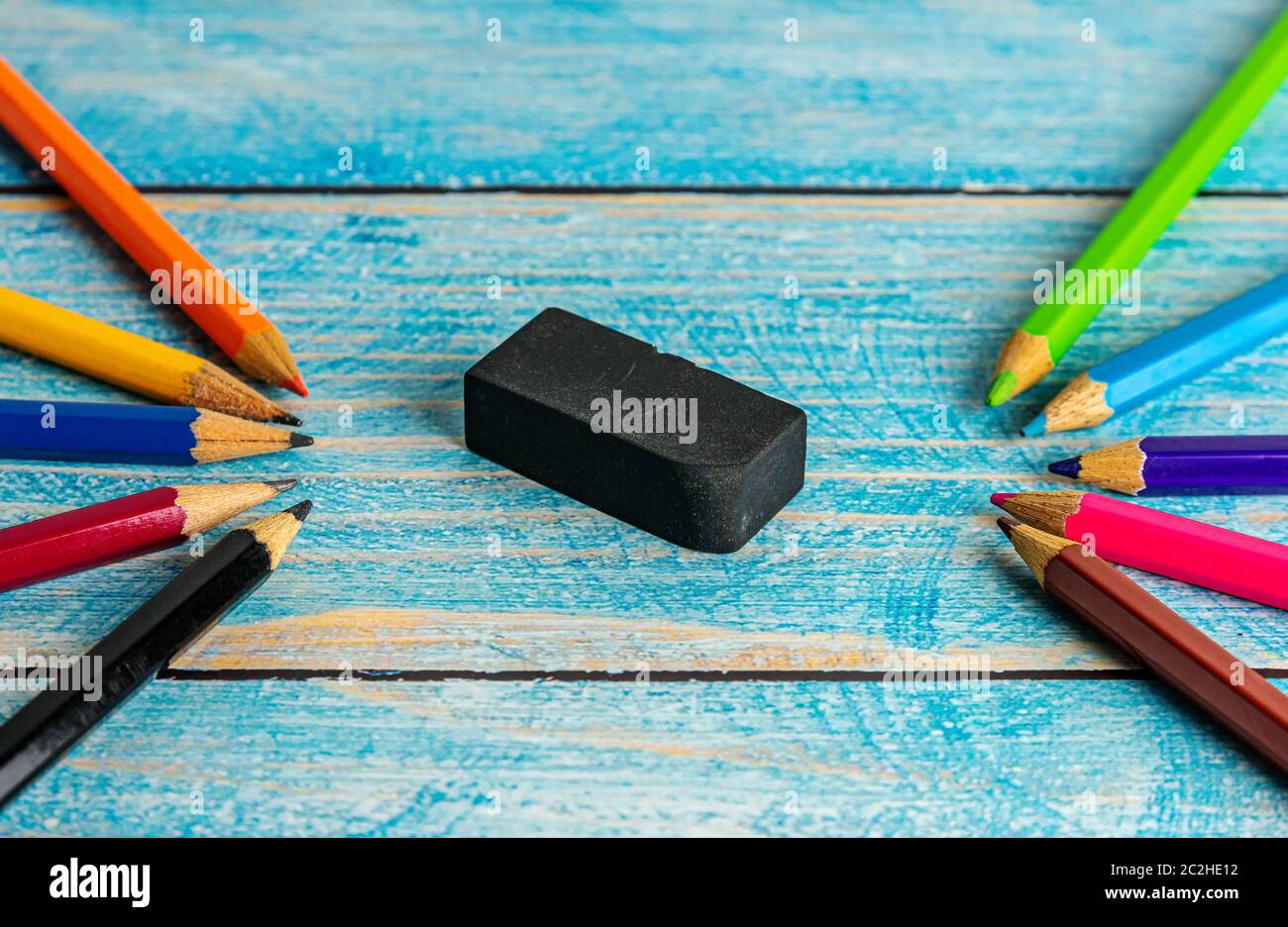 Difference And Strange Concept, All pencil colorful sharpener and eraser on blurred blue wooden table background Stock Photo